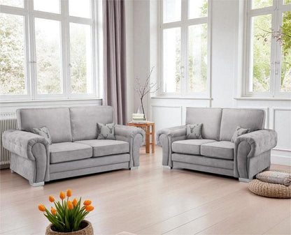 Gray sofa set in a bright living room with large windows and a small table.