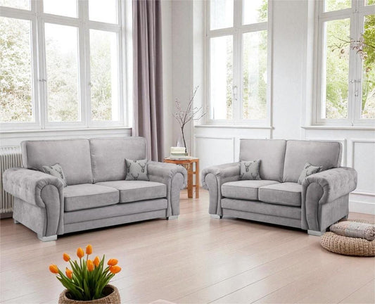 Gray sofa set in a bright living room with large windows and a small table.