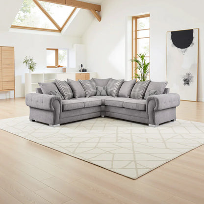 Gray sectional sofa in a modern living room with large windows and light wood flooring.