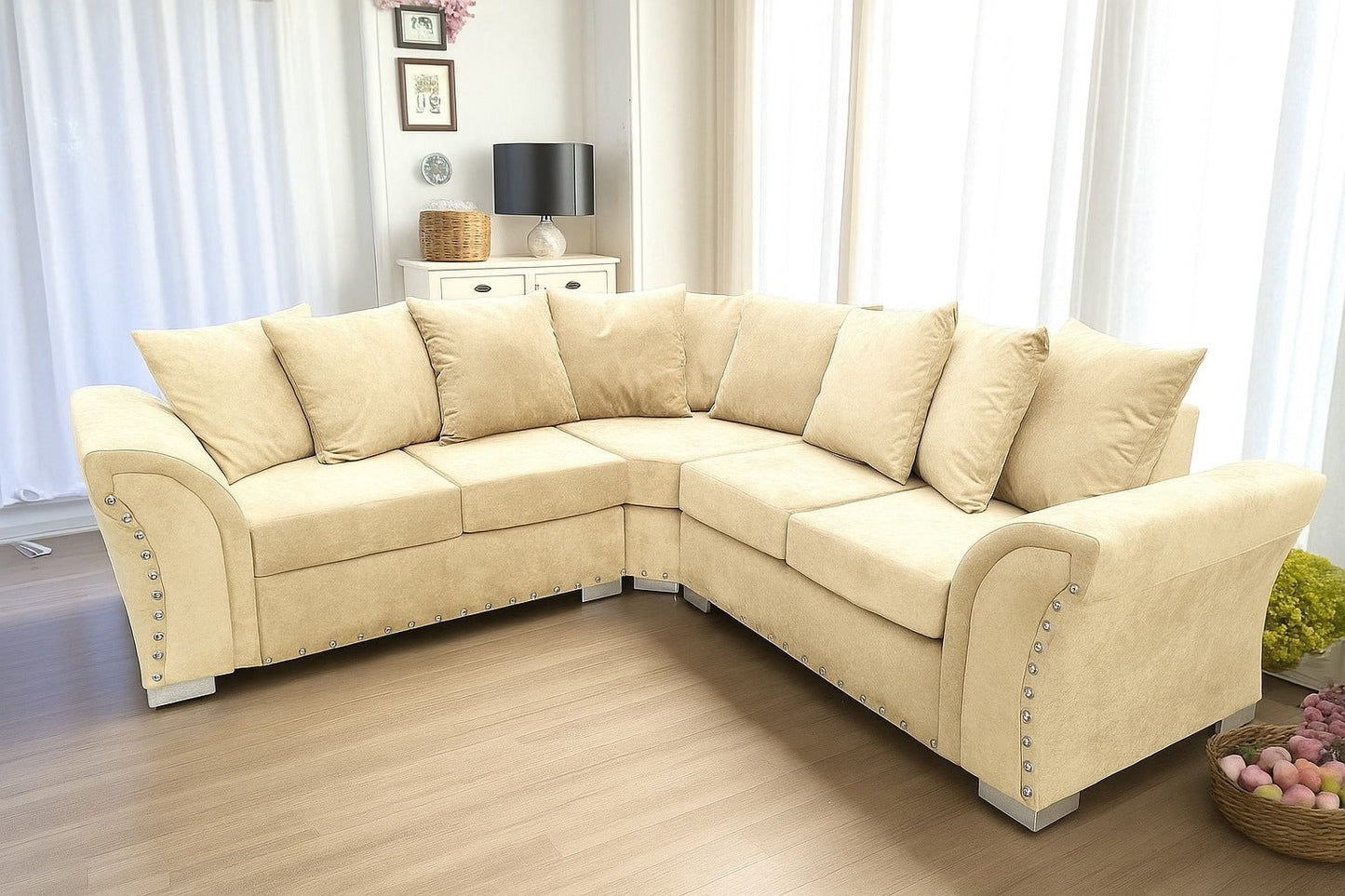cream sectional sofa in a living room setting with light wood flooring and white curtains.