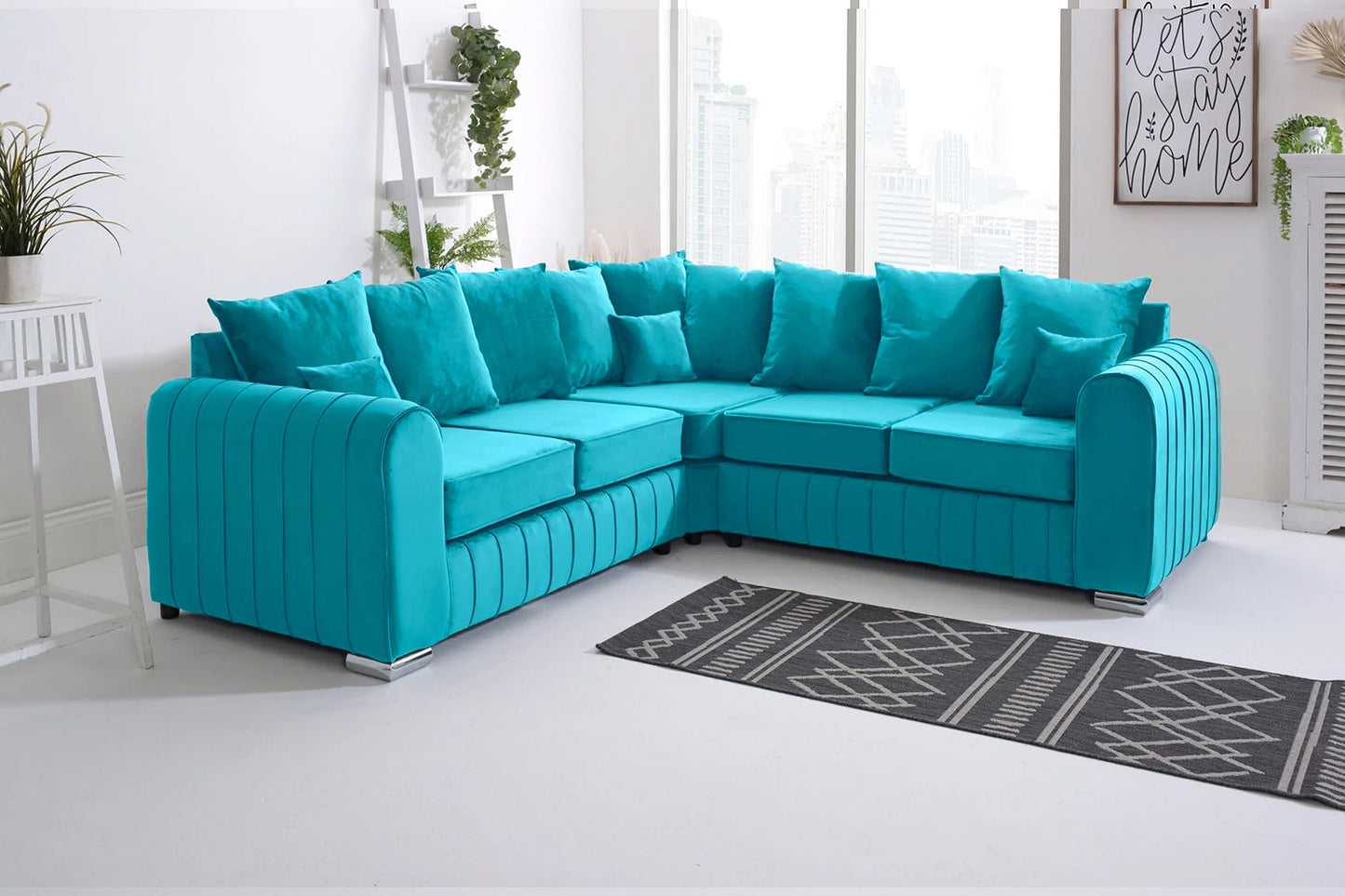 Turquoise sectional sofa in a living room setting with a rug and plants.