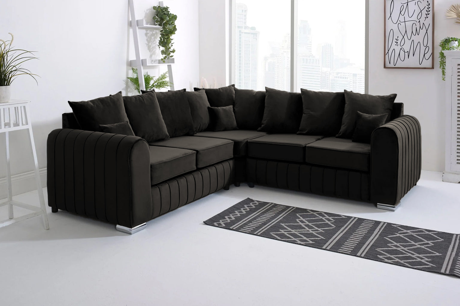 Black sectional sofa in a modern living room with a rug and decor items.