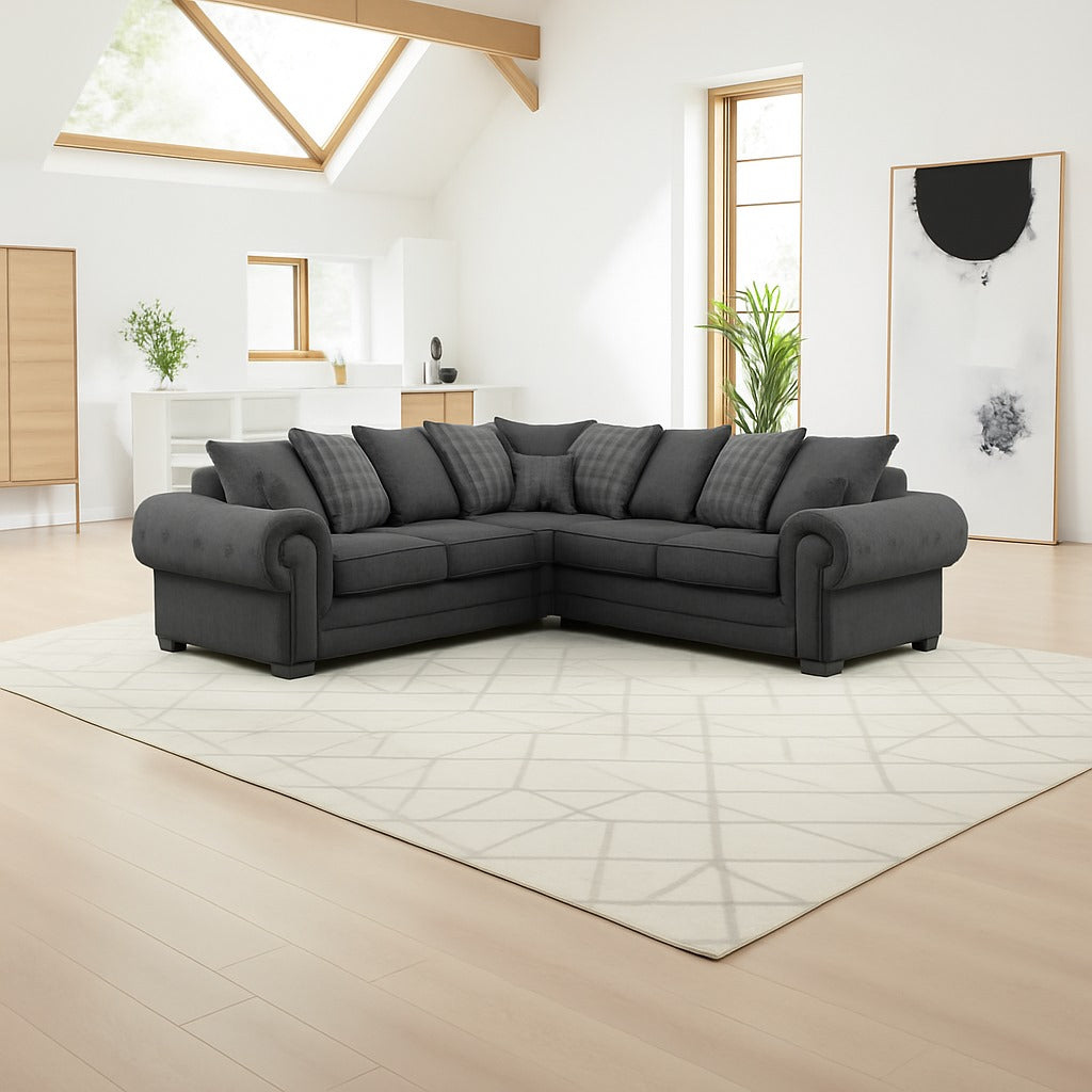 coal sectional sofa in a modern living room with light wood flooring and white walls.